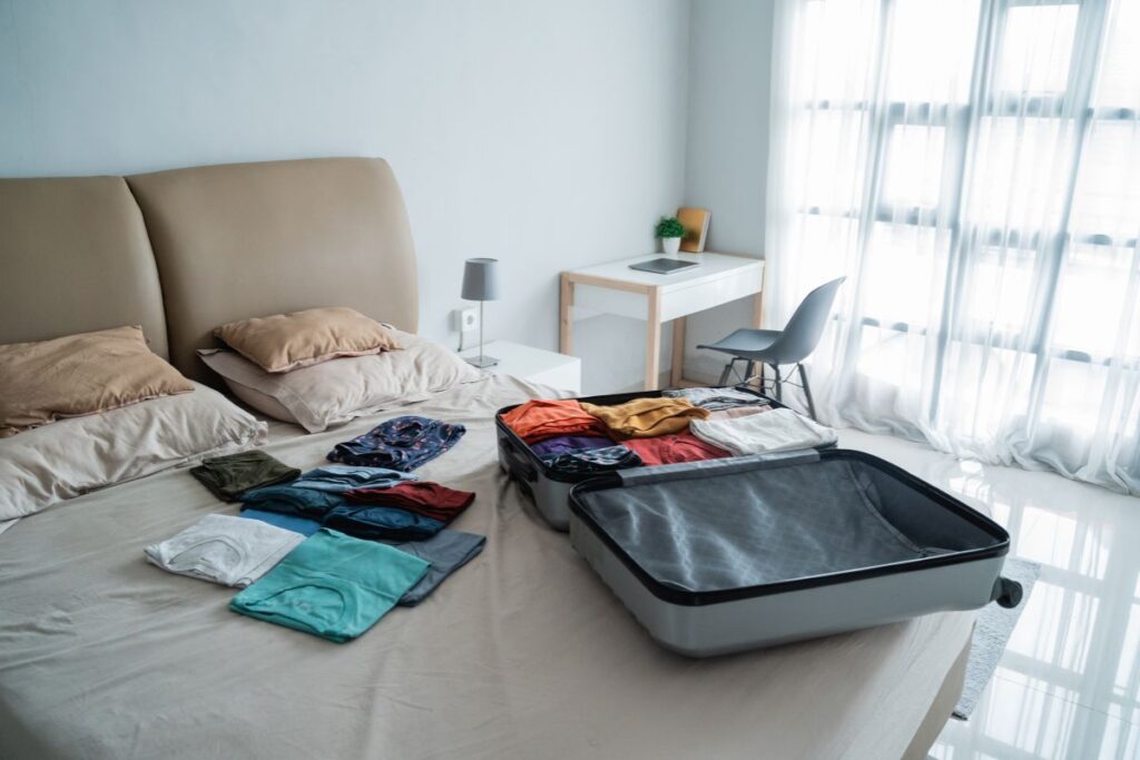 Ropa combinada sobre la cama como parte de consejos para empacar en pareja