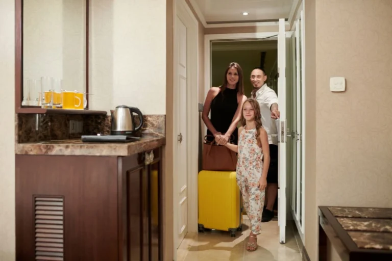 Hospedaje - Familia entrando a una habitación de hotel con maletas
